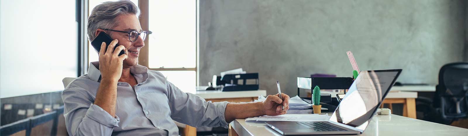 a man on a cell phone working on his laptop